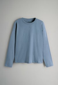 Hellblaues langärmliges T-Shirt aus weichem Stoff, mit rundem Halsausschnitt und lockerer Passform, mit Nähdetails entlang der Nähte.