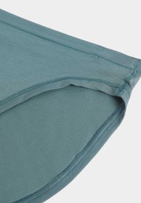 Tessuto in misto cotone verde acqua con una texture liscia, caratterizzato da cuciture piatte lungo i bordi e una leggera lucentezza, tagliato in una forma morbida e arrotondata.