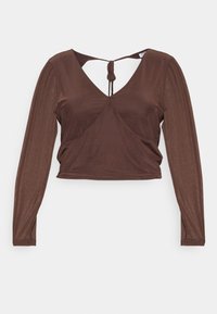 Top de manga longa castanho feito de um tecido macio e leve. Apresenta um decote em V profundo e um detalhe de laço nas costas. Design curto.
