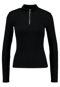 Svart långärmad topp med hög krage, med en silverdragkedja vid halsen. Tillverkad av ribbat tyg, vilket ger en figurnära silhuett.