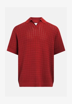 Polo en maille rouge à manches courtes avec motif texturé, col et poignets côtelés, et ouverture en V sans boutons.