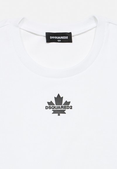 Chemise blanche avec logo DSQUARED2 noir et symbole de feuille d'érable centré sous le col, étiquette de taille 12Y à l'intérieur.