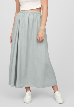Falda de largo hasta el tobillo, plisada y de color gris claro, con cintura elástica; combinada con zapatillas deportivas blancas. La textura parece suave y fluida.