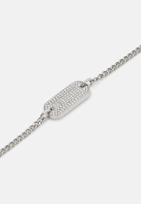 Pulsera de cadena de plata con un charm rectangular alargado, que presenta una superficie texturizada de pequeñas piedras preciosas transparentes.