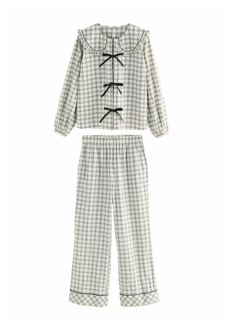 Tjekkede pyjamas sæt i hvid og marineblå. Har en flæsekantet krave, lange ærmer og frontbinder. Elastisk talje på bukserne med pipede manchetter.