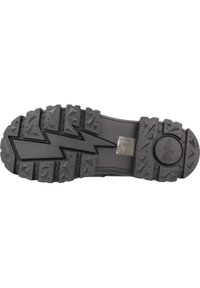Suola di scarpa in gomma nera con evidenti motivi a zigzag e a triangolo, superficie testurizzata e dettaglio del logo circolare.