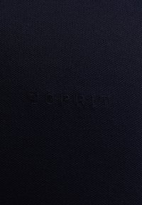 Tmavě texturovaná tkanina s jemně reliéfním logem "ESPRIT" ve shodné tmavé barvě uprostřed.