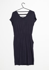 Mörk marinblå klänning hänger på en svart krok. Har V-ringning, korta ärmar, elastisk midja, fickor och tre horisontella skärsträngar på baksidan.