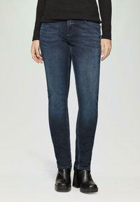 Dunkelblaue Skinny Jeans mit glattem Denim-Material, klassischem Fünf-Taschen-Design und subtiler Ausbleichung auf der Vorderseite.