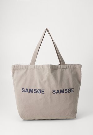 Grijze canvas boodschappentas met twee marineblauwe "SAMSOE" logo's, twee verlengde stoffen handvatten en een zachte structuur. Ideaal voor casual gebruik.