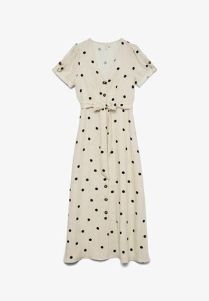 Robe midi crème à pois noirs, manches courtes bouffantes, boutons sur le devant et ceinture à nouer à la taille.