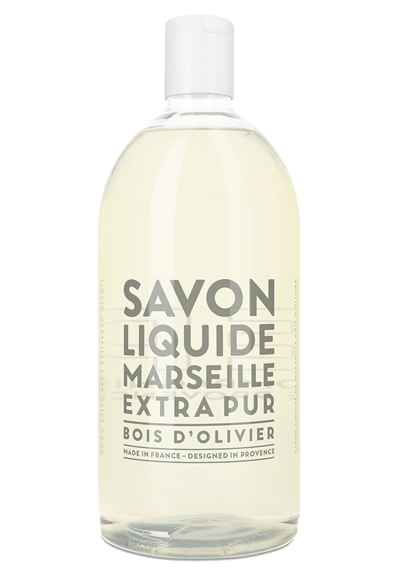 Transparante plastic fles met vloeibare zeep met een witte dop. Het etiket heeft vetgedrukte zwarte tekst: "SAVON LIQUIDE MARSEILLE EXTRA PUR BOIS D'OLIVIER."