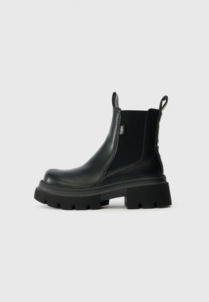 Mustad mustred Chelsea saapad, millel on elastsed külgpaneelid, tekstuuriga viimistlus ja paks, tugeva tallaga põhi. Omab tõmbenööre mugavaks sissepanemiseks.