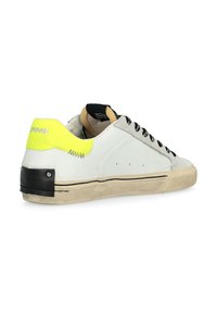 Sneaker bianco in pelle con lacci neri, punta in camoscio grigio testurizzato e dettaglio sul tallone in giallo fluo. Presenta un accento nero sul retro.