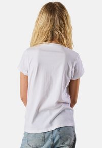 Valkoinen lyhythihainen t-paita, jossa on pyöreä pääntie, valmistettu puuvillasta, ja se näyttää sileältä sekä rentoa istuvuutta.