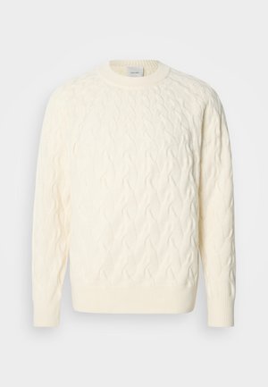 Kremasto pleten pulover s okroglim izrezom in rebrastimi manšetami ter spodnjim robom. Narejen iz mehkega volnenega mešanega materiala z reliefnim vzorcem.