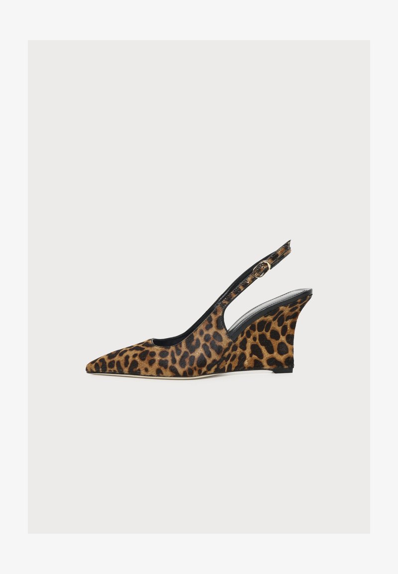 Chaussure à talon compensé motif léopard, bout pointu, doublure intérieure noire et bride de cheville réglable, présentée sur fond blanc uni.