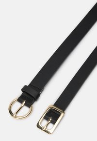 Cinto de couro preto com uma textura lisa. Apresenta uma fivela redonda em tom dourado e uma fivela quadrada em tom dourado para fecho ajustável.