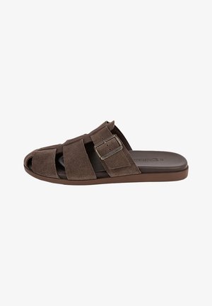 Bruine suède instapsandaal met open teen, brede bandjes en verstelbare metalen gesp op een platte zool.