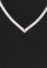 Haut noir côtelé avec un décolleté en V, agrémenté d'un embellissement en cristaux argentés le long des bords. La texture est lisse et ajustée.