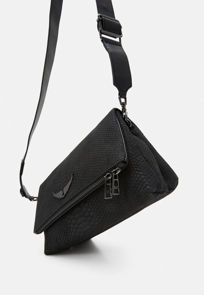 Black textured crossbody bag with a foldover design, featuring a zippered compartment and an adjustable strap. Accented with a metallic logo.