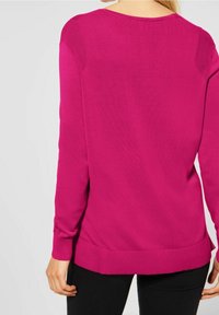 Magenta svetr s dlouhými rukávy, žebrovanými manžetami a lemem. Obsahuje strukturované detaily na ramenou a kulatý výstřih.