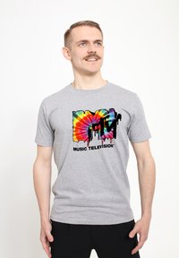 Šedé bavlněné tričko s mnohobarevným tie-dye logem MTV s efektem kapající barvy a černým textem "MUSIC TELEVISION."
