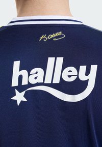 Jūrų karinės uniformos džersis su ryškiai baltu užrašu "halley" ir žvaigždės grafika. Unikalus geltonas akcentas virš užrašo. Balti juostuoti apykaklės akcentai.