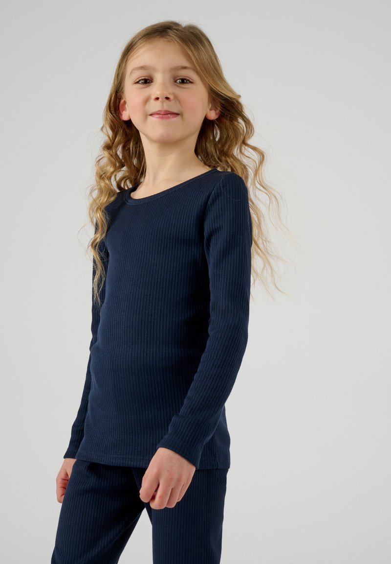 Camiseta de manga larga de canalé en color navy y pantalones a juego. Tejido suave con un diseño ajustado, que presenta un escote redondeado y una superficie texturizada.