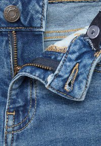 Denim tkanina sa izblijedjelom plavom bojom, s patentnim zatvaračem i dugmetom za zatvaranje, kontrastnim šavovima i rastrganim rubovima na struku.