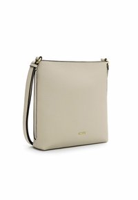 Borsa a tracolla in pelle beige con una texture liscia, forma rettangolare, dettagli in metallo dorato e bordi neri a contrasto.
