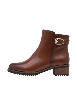 Brown leather ankle boot with low stacked heel, rounded toe, black rubber sole, and decorative gold buckle strap near the top.