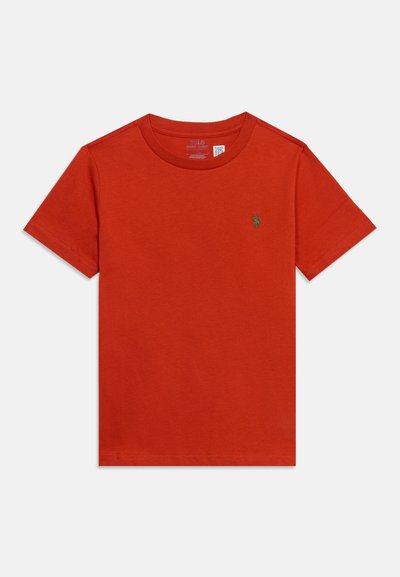 Απλό κόκκινο t-shirt με κοντά μανίκια και στρογγυλή λαιμόκοψη, με μικρό πράσινο κεντητό λογότυπο στο αριστερό στήθος και ορατή εσωτερική ετικέτα.