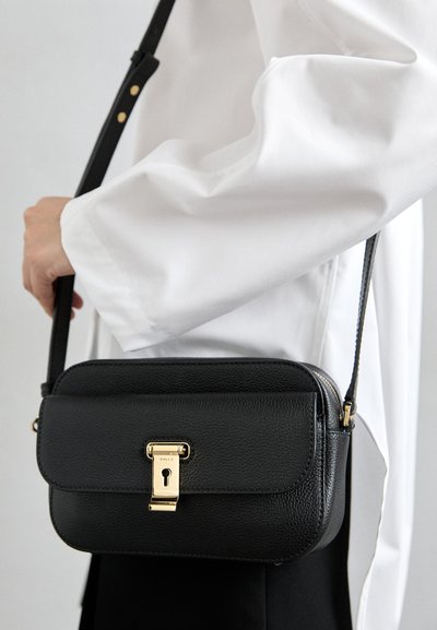 Svart läder crossbody-väska i rektangulär form, texturerad yta, guldhårdvaruknäppning och justerbar rem.