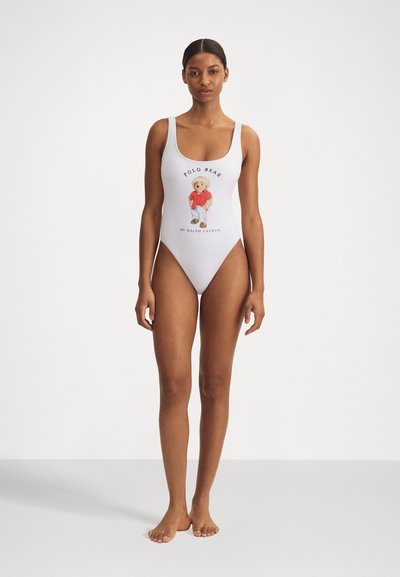 Costum de baie întreg alb, cu un grafic colorat de urs de desene animate și textul "Polo Bear" cu accente negre. Material neted și elastic.