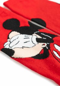Calze rosse con un design di personaggio dei cartoni animati in bianco e nero. Il materiale è a maglia con una texture liscia. I dettagli notevoli includono caratteristiche facciali distintive del cartone animato.