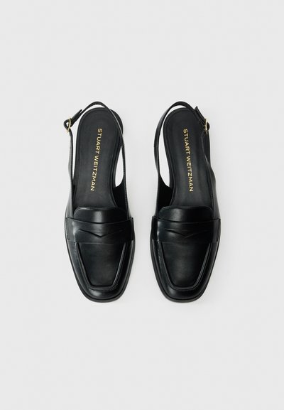 Scarpe slingback in pelle nera con punta squadrata, fascetta decorativa frontale e logo dorato sulla soletta. Texture liscia e design minimale.