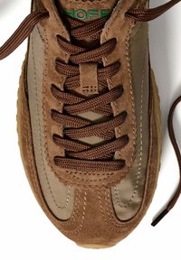 Sneaker marroni con tomaia in suede e tessuto, dotate di lacci testurizzati, dettagli cuciti e suola in gomma. Logo verde sulla linguetta.
