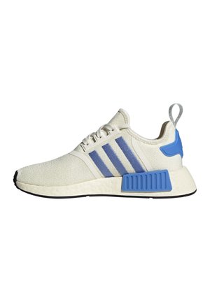 Baskets de sport blanches avec des bandes bleues, des blocs de support de semelle bleus, des lacets blancs et une languette grise au talon.