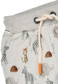 Graue Jogginghosen mit einem Kordelzug-Bund in Cremefarbe, verziert mit verschiedenen Tiermustern, darunter Tiger, Zebras und Schildkröten.