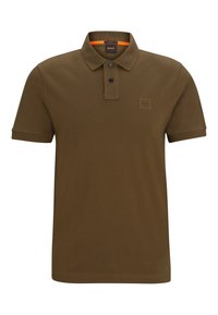 Polo vert olive, manches courtes, tissu en coton doux, patte de boutonnage à deux boutons, patch de marque sur la poitrine, bande contrastante orange au col.