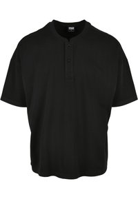 Svart t-skjorte med korte ermer laget av bomull, med en henley-halslinje med to knapper og dropped shoulder-sømmer.