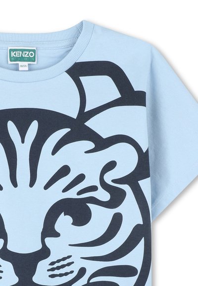 Chemise à manches courtes bleu clair en coton, ornée d'un grand graphique de tigre noir marine sur le devant et d'un col rond.