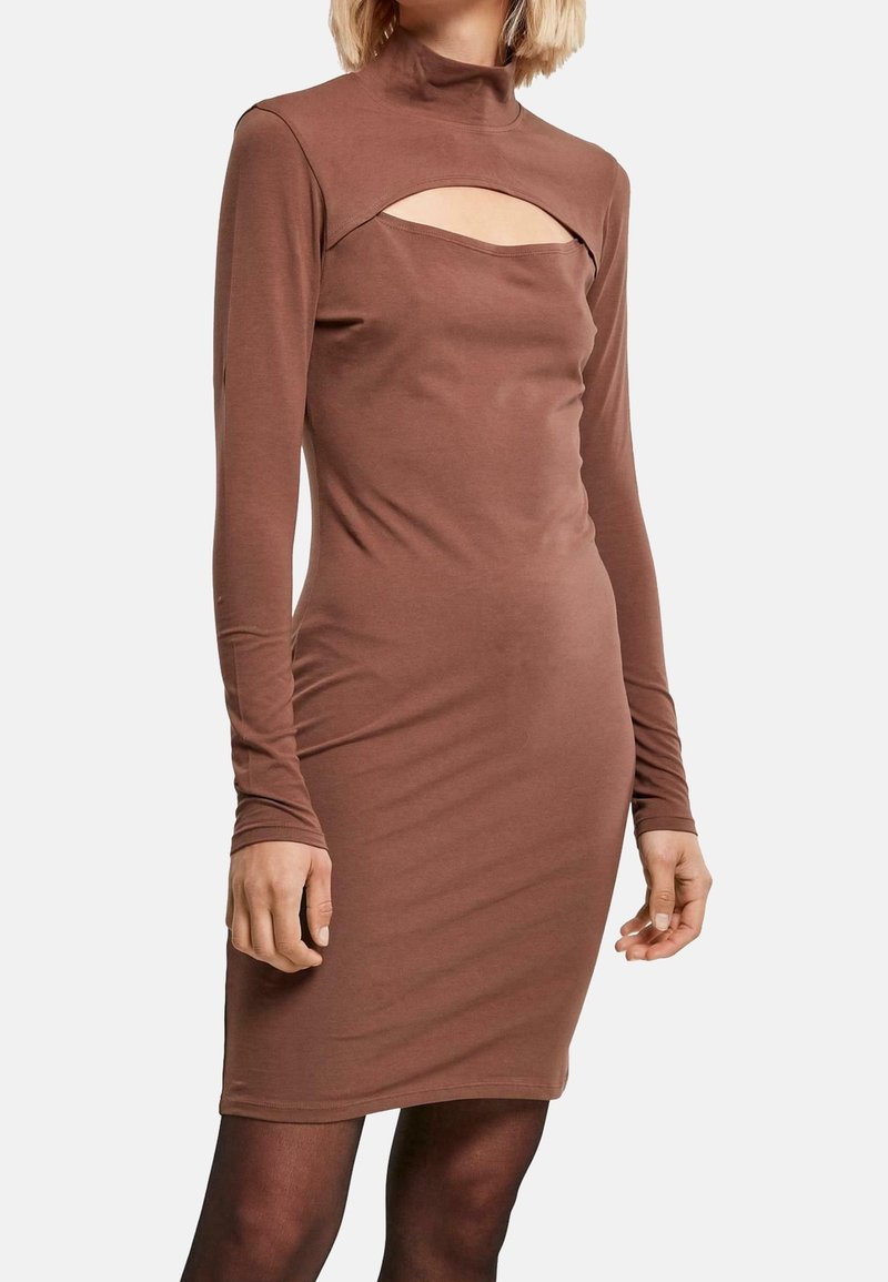 Abito marrone a maniche lunghe con collo alto e un taglio sotto il collo. Realizzato in tessuto elasticizzato con silhouette aderente.
