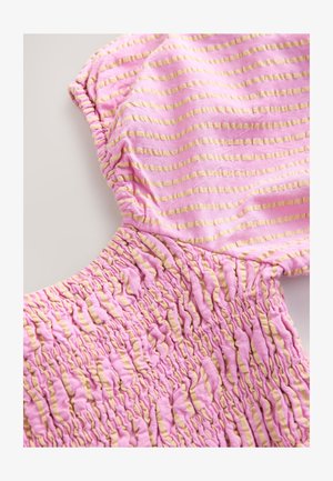 Vaaleanpunainen ja keltaraitainen kangas, jossa on kerätty rakenne ja röyhelöidyt reunat. Materiaali näyttää pehmeältä ja joustavalta, sopiva rentoon pukeutumiseen.