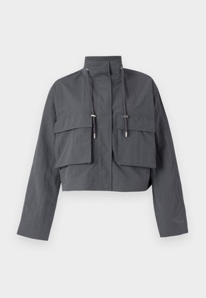 Veste grise cintrée avec un col haut, deux grandes poches avant, des détails à cordon et un tissu léger et texturé.