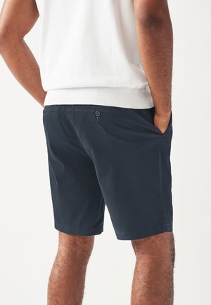 Donkerblauwe shorts met een gladde textuur, twee zijzakken en een enkele knoopsluiting aan de achterkant, boven de knie lengte.