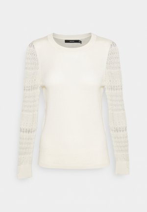 Pull ivoire à manches longues, avec un corps uni, des manches en maille à motifs, un col rond et des poignets côtelés, présenté sur un fond clair.