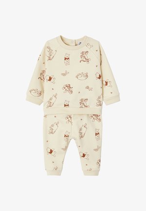 Cream-colored sweatshirt and pants set featuring an all-over print of Winnie the Pooh and friends in brown tones. Soft fabric, ribbed cuffs.