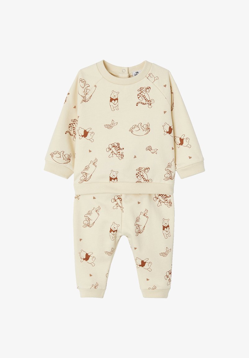 Beige Sweatshirt- und Hosen-Set mit einem Allover-Druck von Winnie Puuh und seinen Freunden in Brauntönen. Weicher Stoff, gerippte Bündchen.